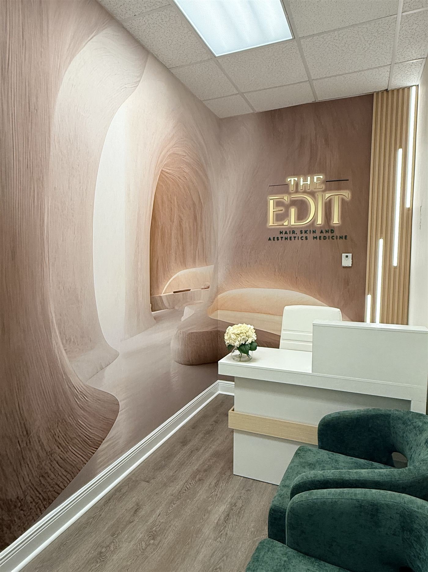 Private consultation room at The Edit with a white and gold desk and an olive tree